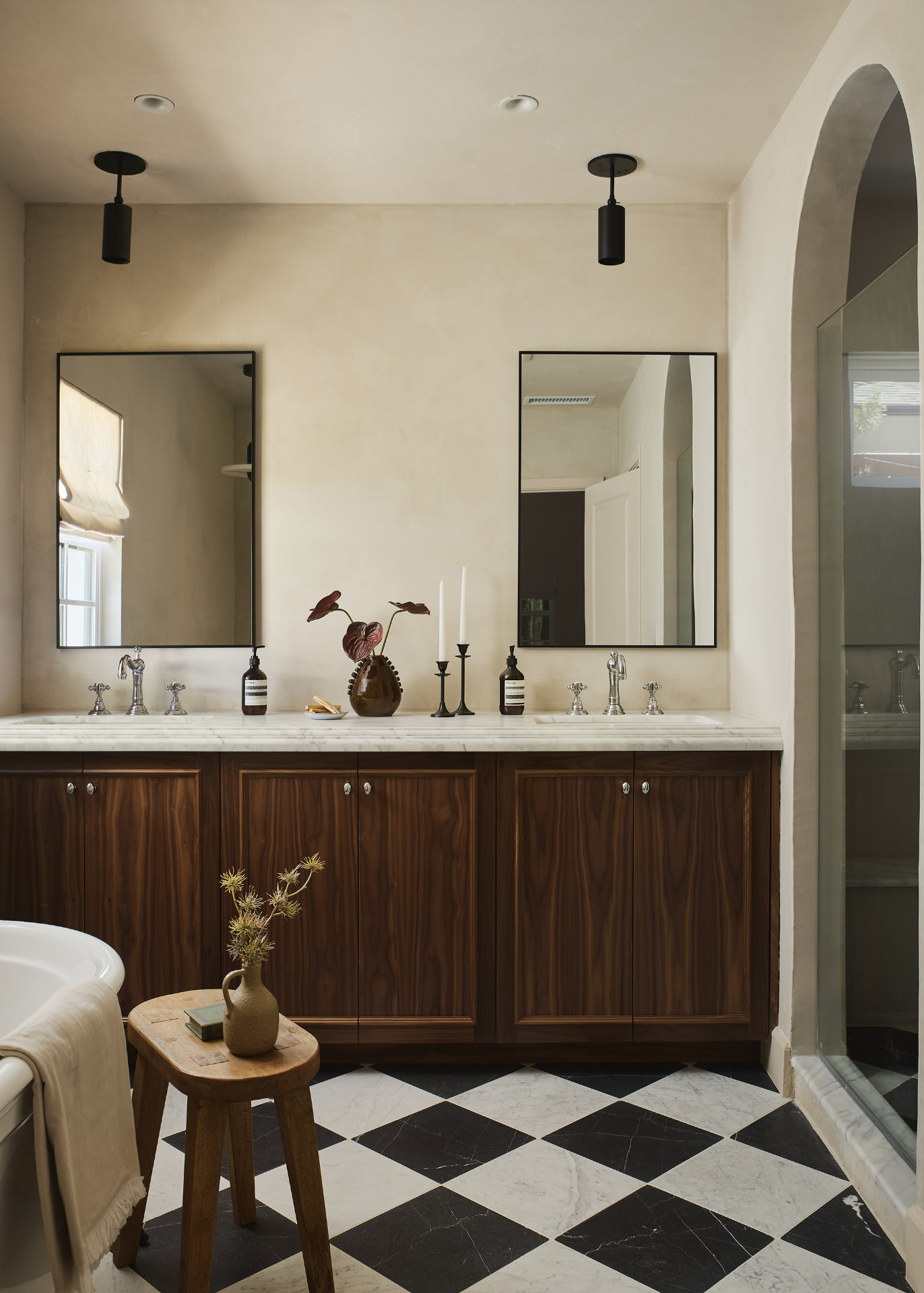 Primary bathroom with walnut vanity, marble counters and checkered marble floor