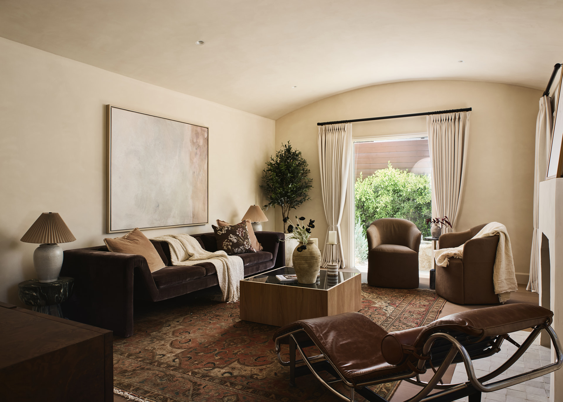 Warm plaster living room with vaulted ceiling, velvet sofa and antique rug