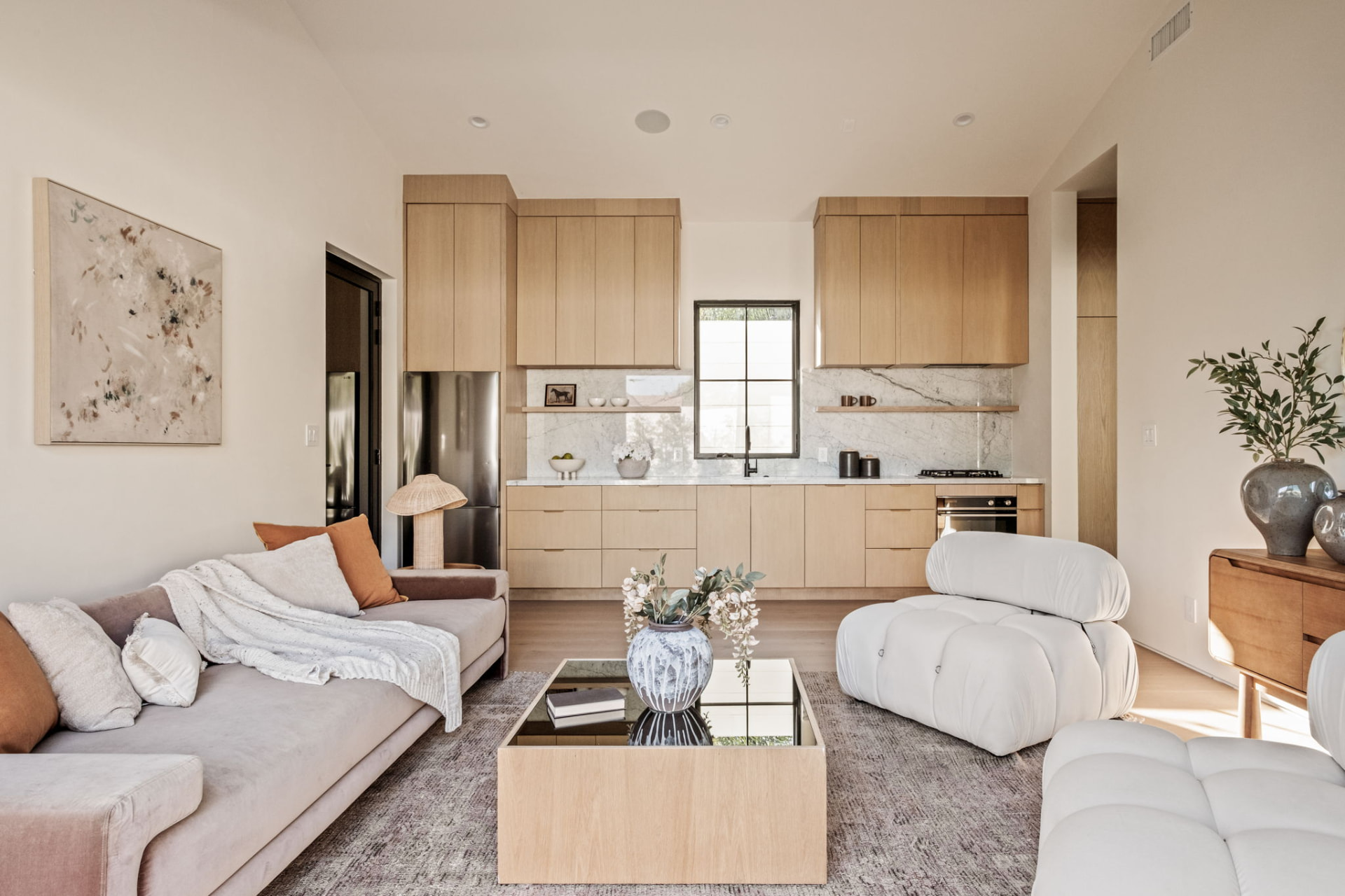 ADU kitchen and lounge with white oak cabinetry, marble backsplash and a mirrored oak coffee table