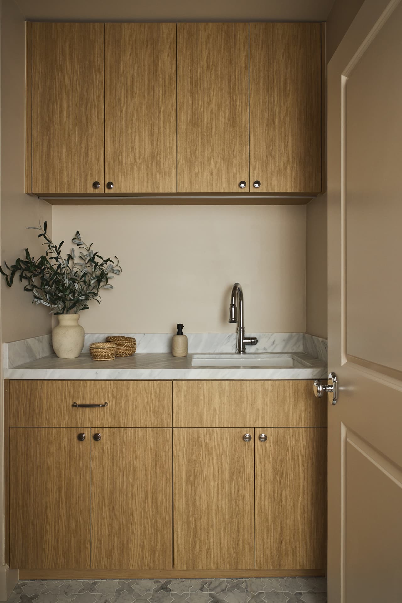 Butler's pantry with oak cabinetry, marble counter and marble mosaic floor