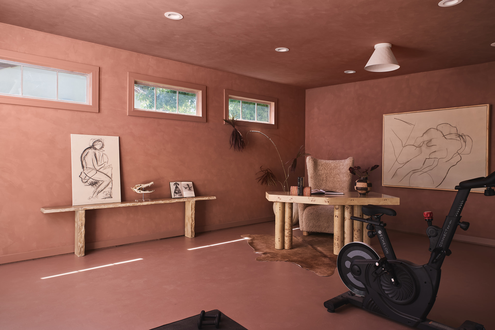 Studio wing in terracotta plaster with clerestory windows, burl console and charcoal artwork