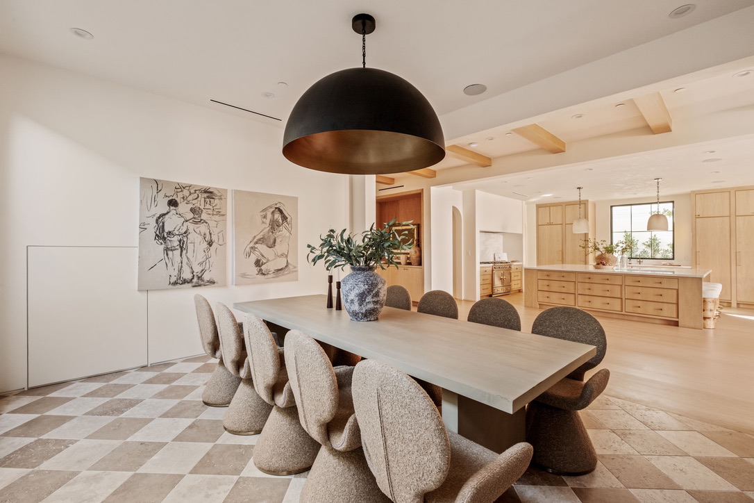 Dining wing with charcoal figure drawings, a bronze dome pendant and a view through to the oak kitchen
