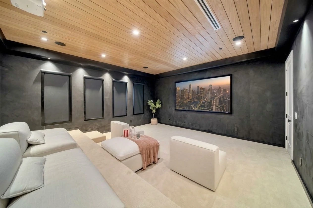 Media room with dark walls, oak plank ceiling, lounge seating and a projection screen